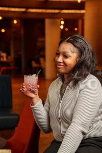 Someone drinking a cocktail at Burdock Cafe, Bar and Restaurant